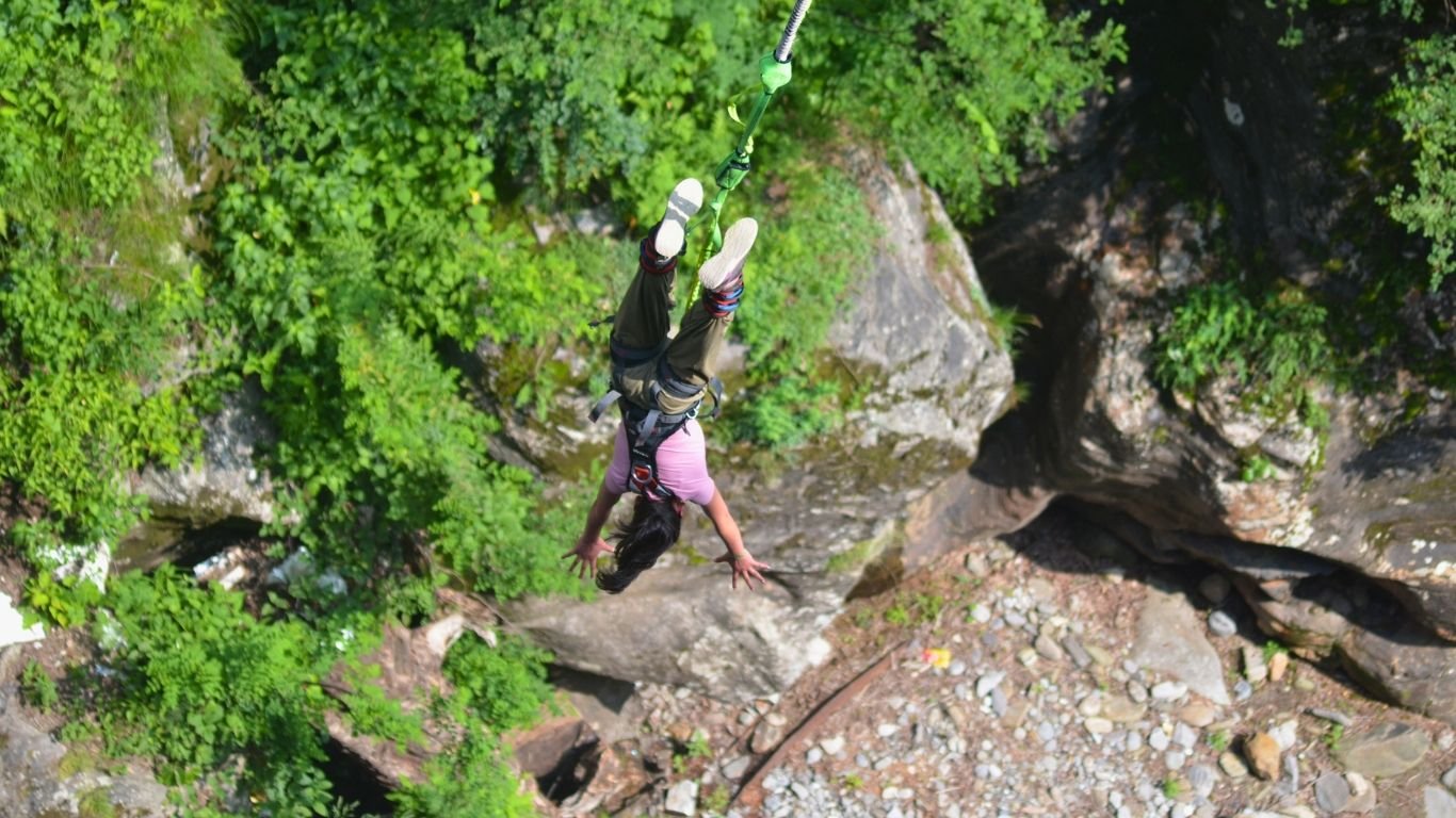 Woman bungee jumping from a high cliff, enjoying an adrenaline rush.
